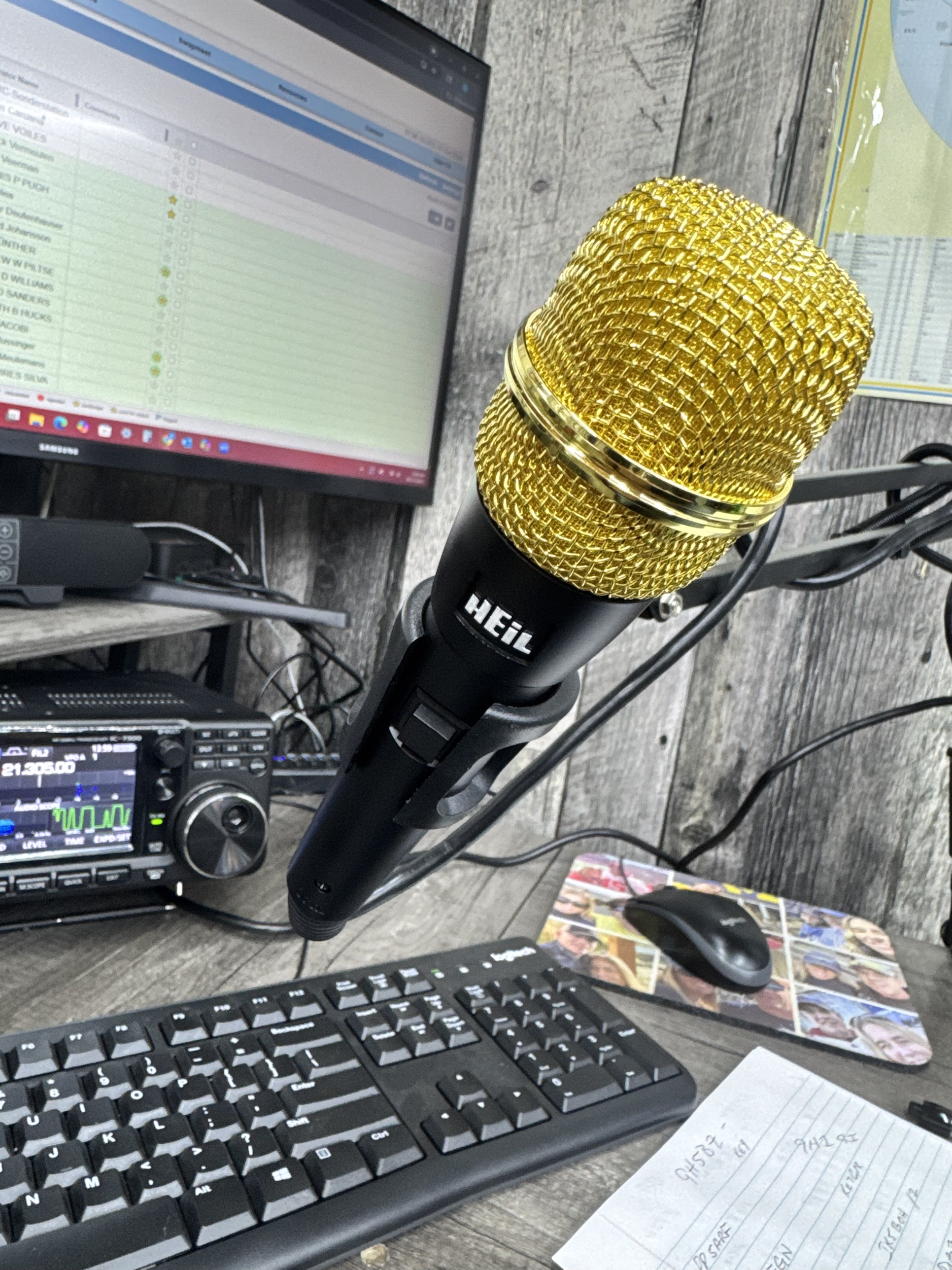 Ham radio shack with an Icom IC-7300 transceiver, Heil microphone, and contest logging software